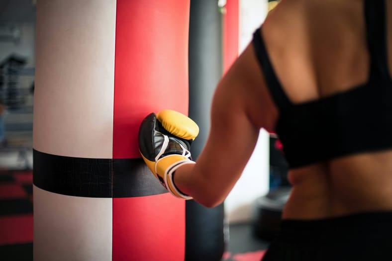 girl hitting punching bag