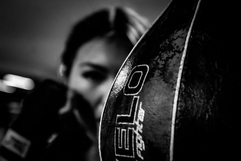female boxer behind punching bag